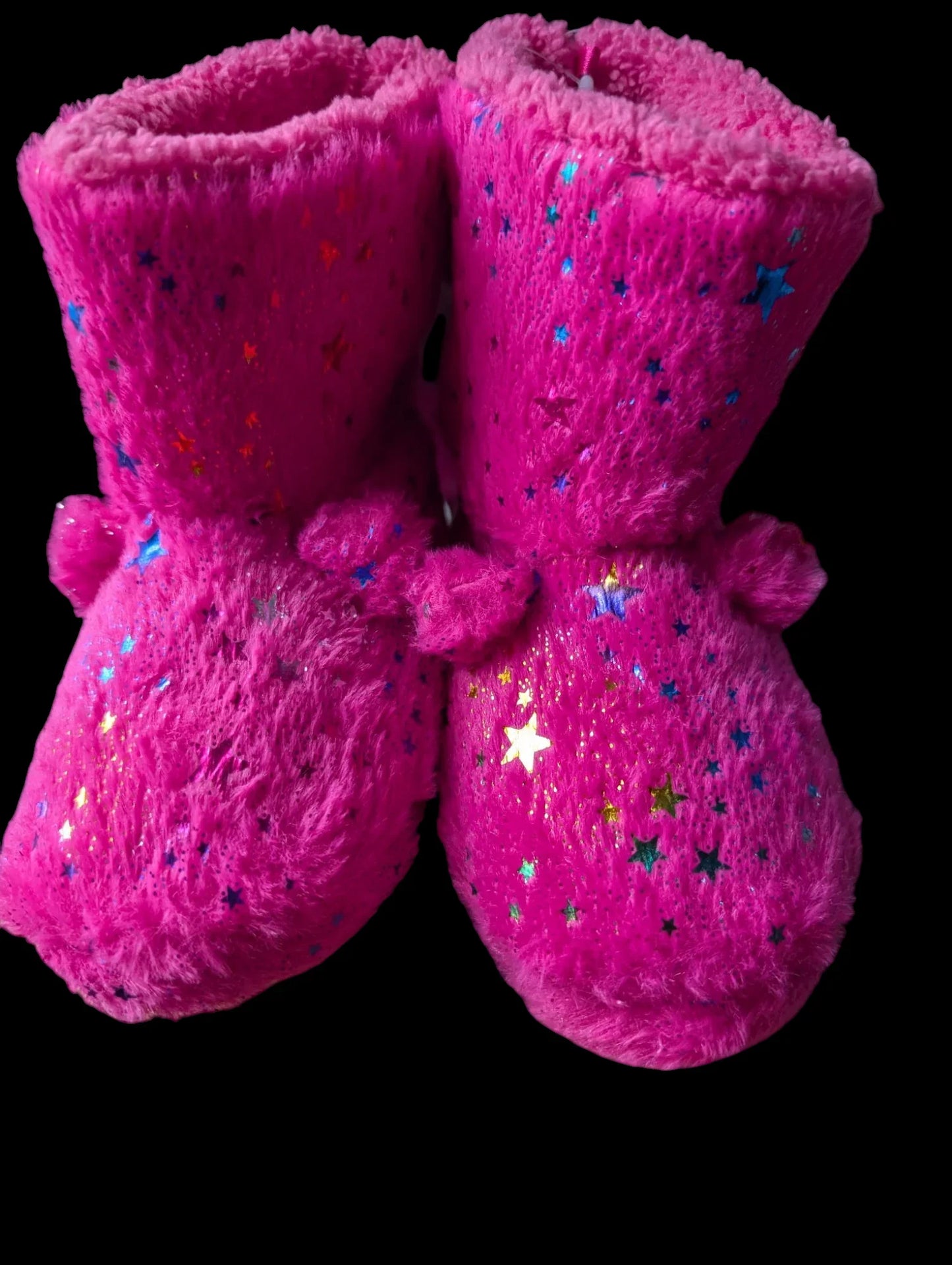 Pair of pink slippers with star patterns on a black background