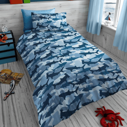 Blue camouflage bedspread on a bed in a child's bedroom with toys and a nightstand.