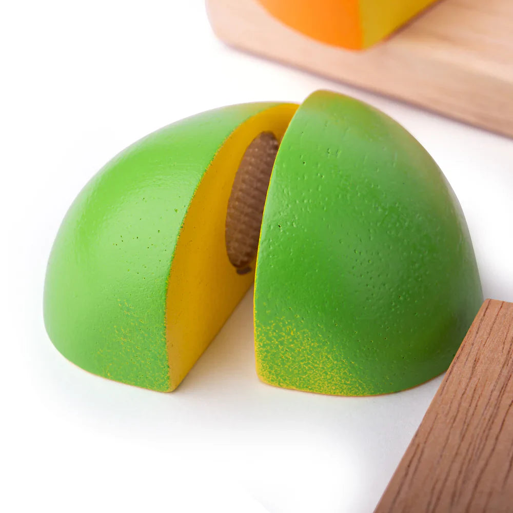 Toy avocado cut in half on a white background