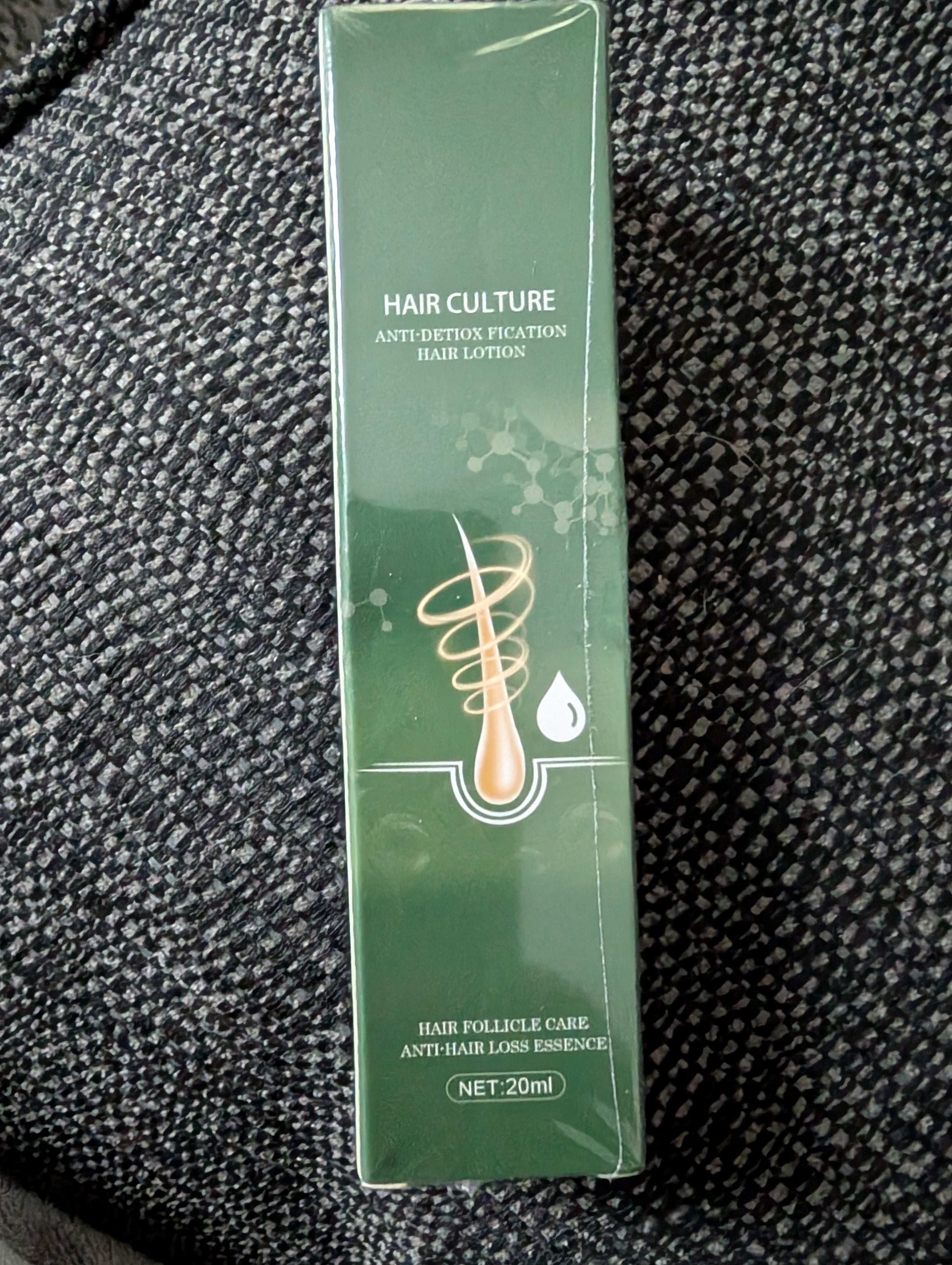 Green hair care product box on a textured black surface