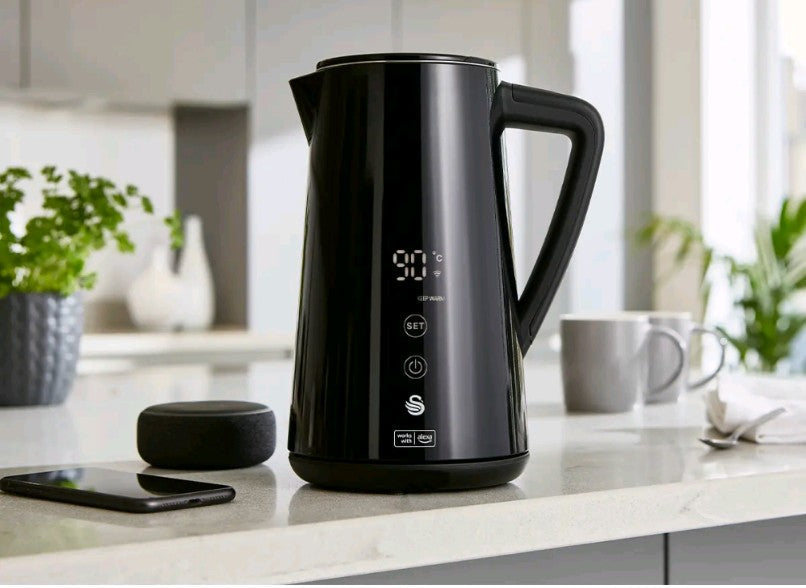 Black electric kettle on a kitchen counter with a blurred background